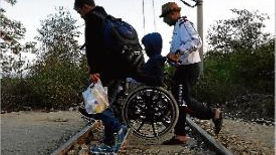 Refugiats sirians creuant una via de tren a Grècia.