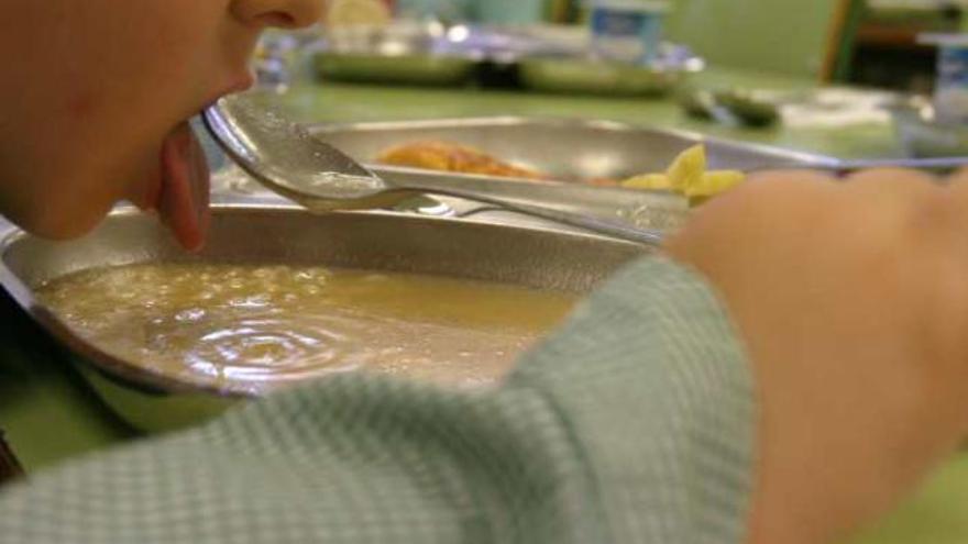 Imagen de archivo de un niño comiendo en un comedor escolar.