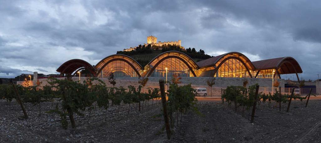 Las vanguardistas instalaciones de la bodega Protos, diseñadas por el arquitecto Richard Rogers, Premio Pritzker de Arquitectura 2007, con el castillo de Peñafiel al fondo. 