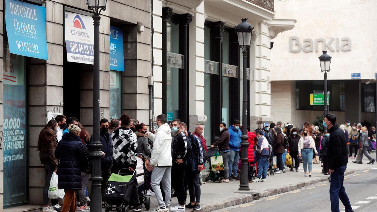 Un numeroso grupo de personas guarda cola durante el reparto de alimentos llevado a cabo ayer por integrantes de la plataforma integrada por organizaciones sociales &quot;Esperanza Obrera&quot; en el edificio ocupado la semana pasada en el centro financiero de la ciudad.