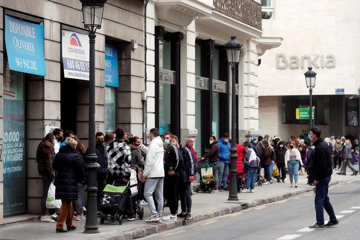Un numeroso grupo de personas guarda cola durante el reparto de alimentos llevado a cabo ayer por integrantes de la plataforma integrada por organizaciones sociales "Esperanza Obrera" en el edificio ocupado la semana pasada en el centro financiero de la ciudad.