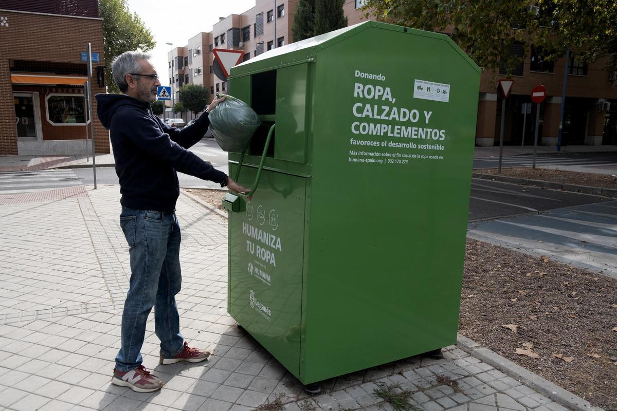 Un donante de ropa de segunda mano en un contenedor de Humana de Madrid.
