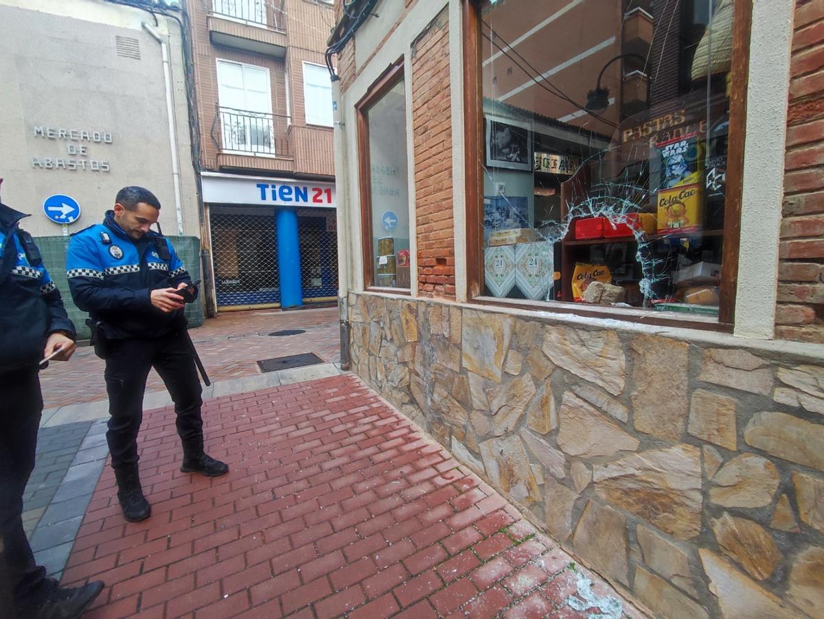 La Policía tras sorprender este doingo al vecino de Benavente que robaba en comercios del centro ante el comercio del último asalto.