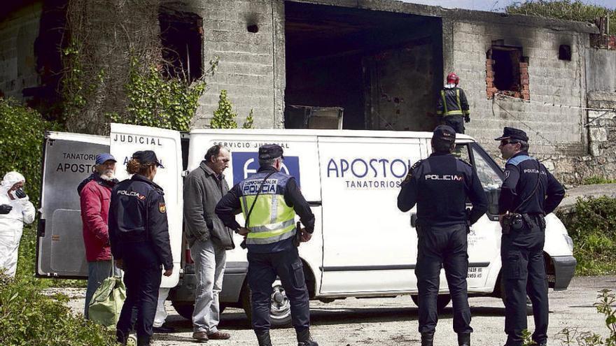 Policías, ayer, ante el furgón funerario que trasladó el cuerpo. // J. Roller