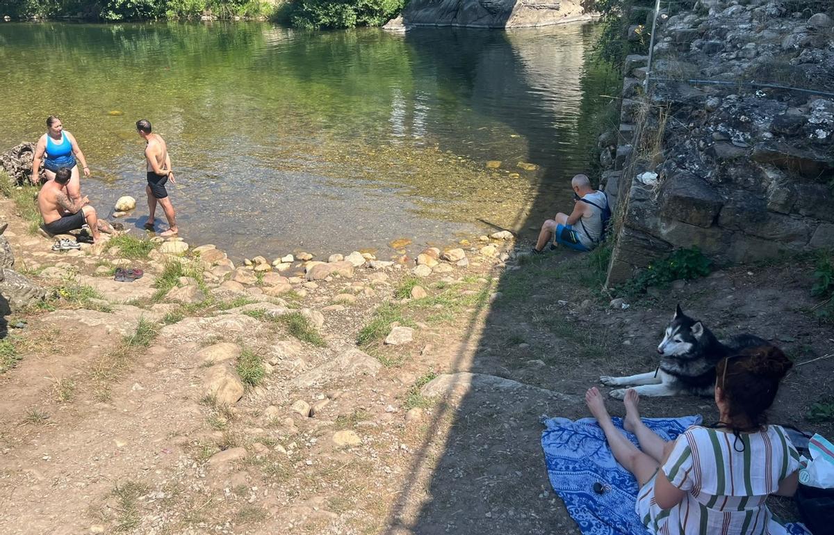 Bañistas combatiendo las altas temperaturas en las inmediaciones del río.