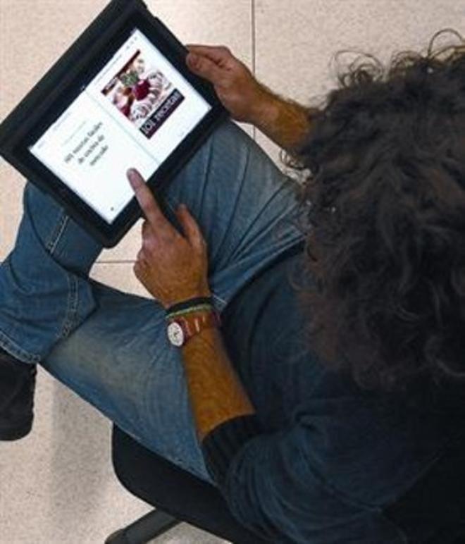 Un lector consulta el llibre electrònic ’101 recetas fáciles...’ en un iPad.