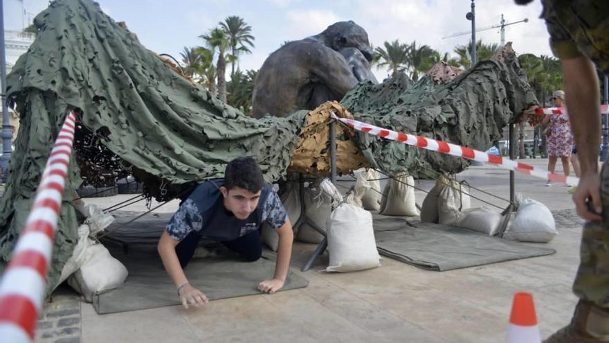 Una niña se coloca el equipamiento militar.