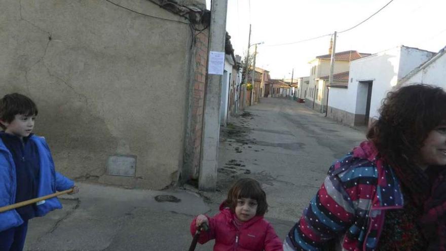 Vecinos de Arcenillas pasan por delante del bando que anuncia la potabilización del agua.