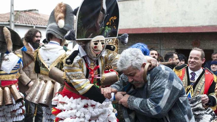 Arriba, un felo agarra a un vecino, y a cara descubierta, el alcalde Rubén Quintas. A la izquierda un felo saluda a dos vecinos en Santirso. // Brais Lorenzo