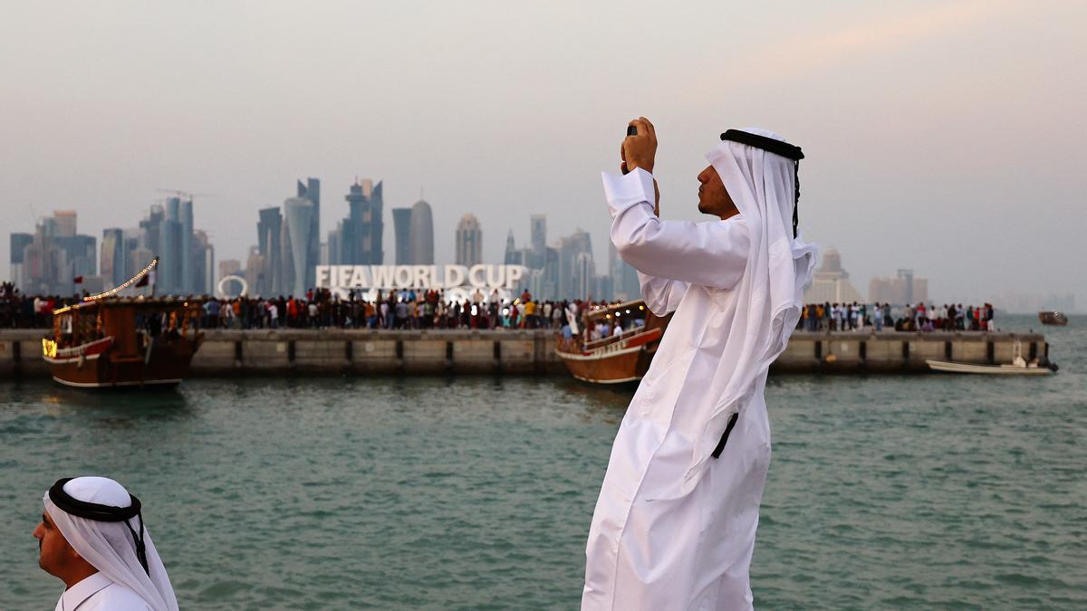 People take pictures at Al Corniche waterfront in Doha