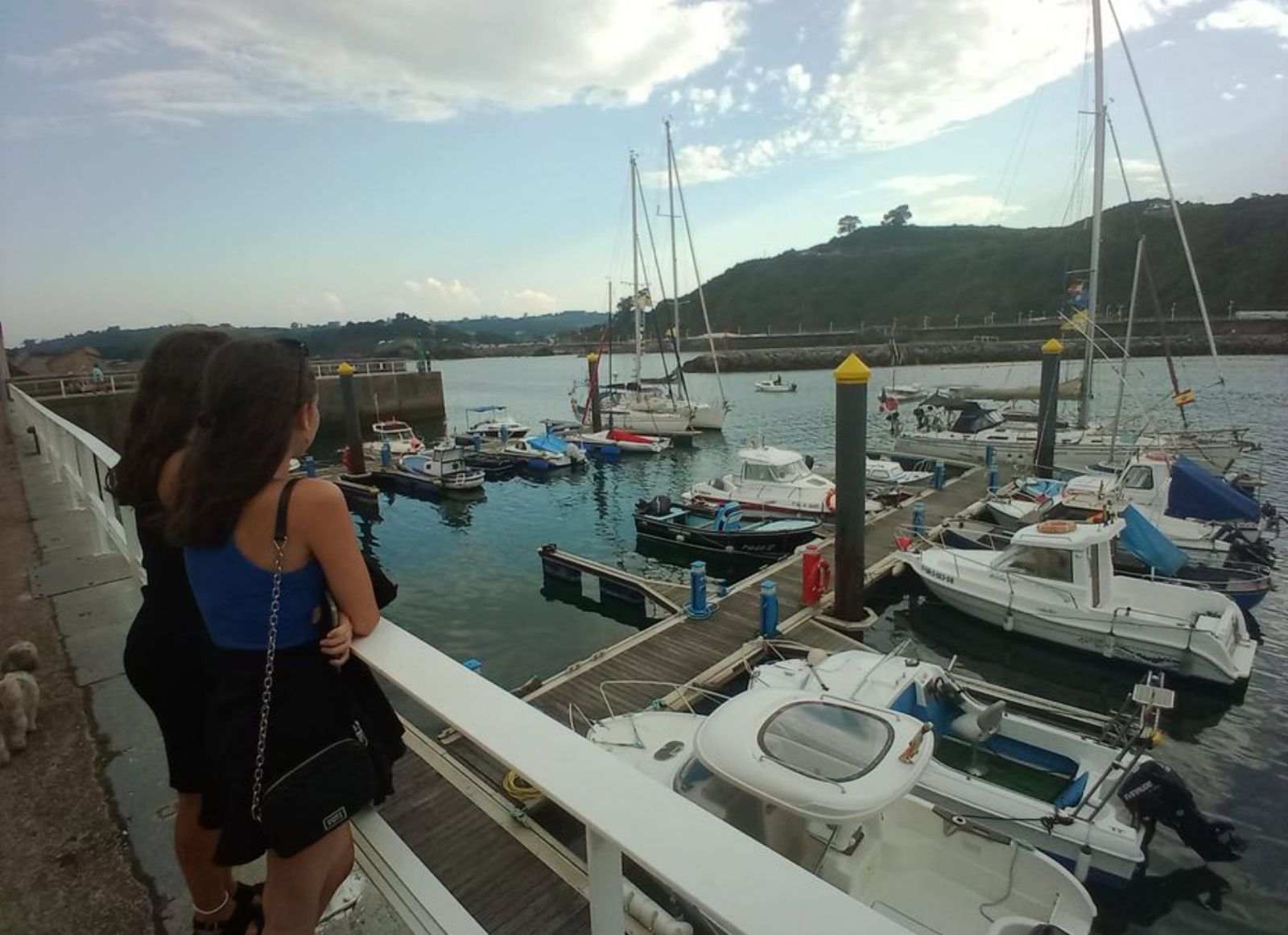 Dos chicas observan algunos barcos de la travesía en el puerto. | B. G.