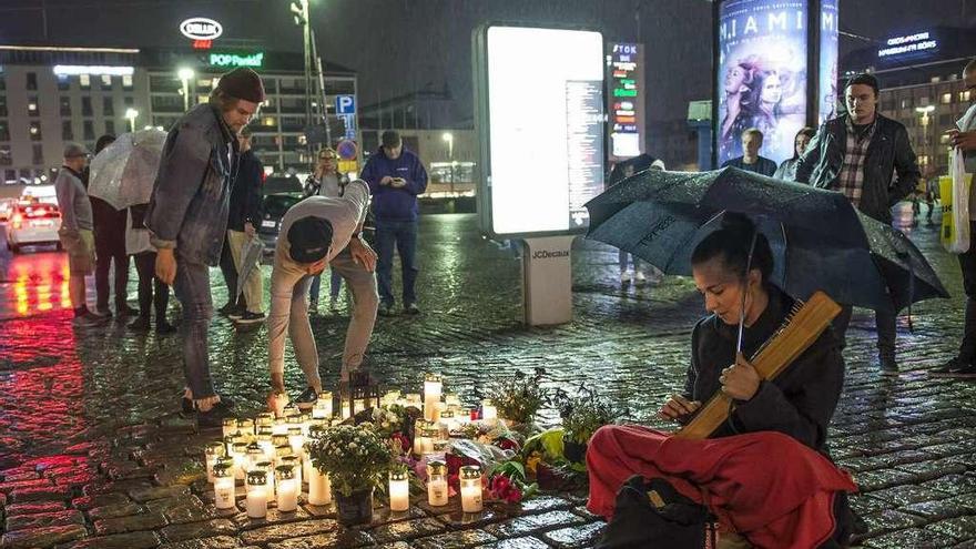 Varios ciudadanos colocan velas en el lugar del ataque en la ciudad de Turku. // Efe