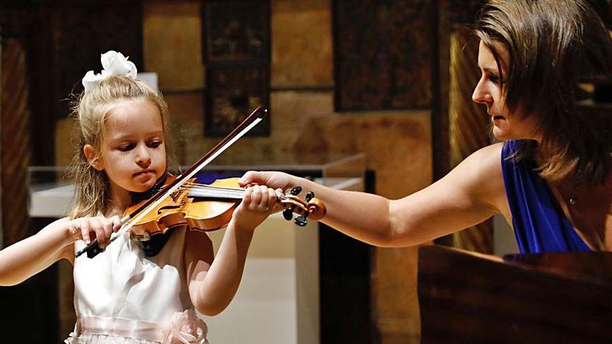 Anya Zhislin toca el violín  junto a su  madre, Natalia Lomeiko, ayer. | M. León