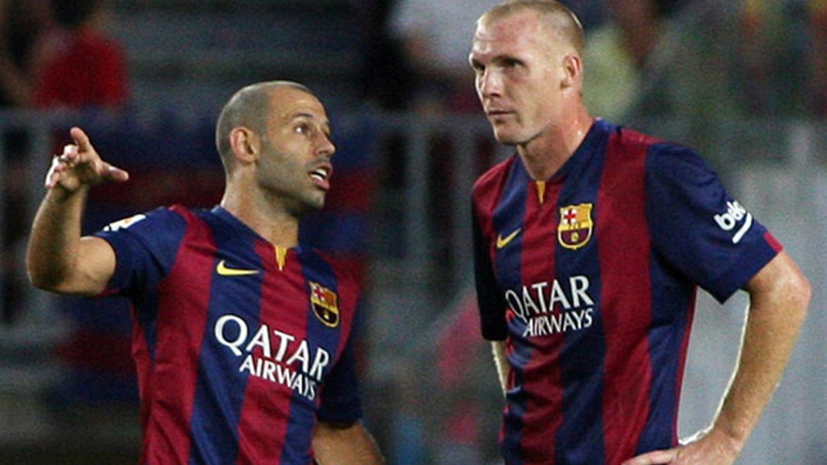 Javier Mascherano y Jeremy Mathieu hablan durante un partido del Barça