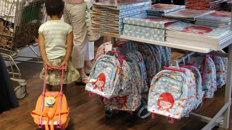 Una familia compra material escolar para una niña.