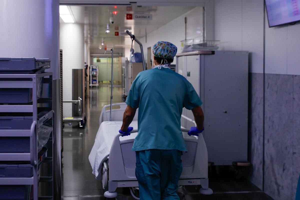 Un celador transporta una camilla