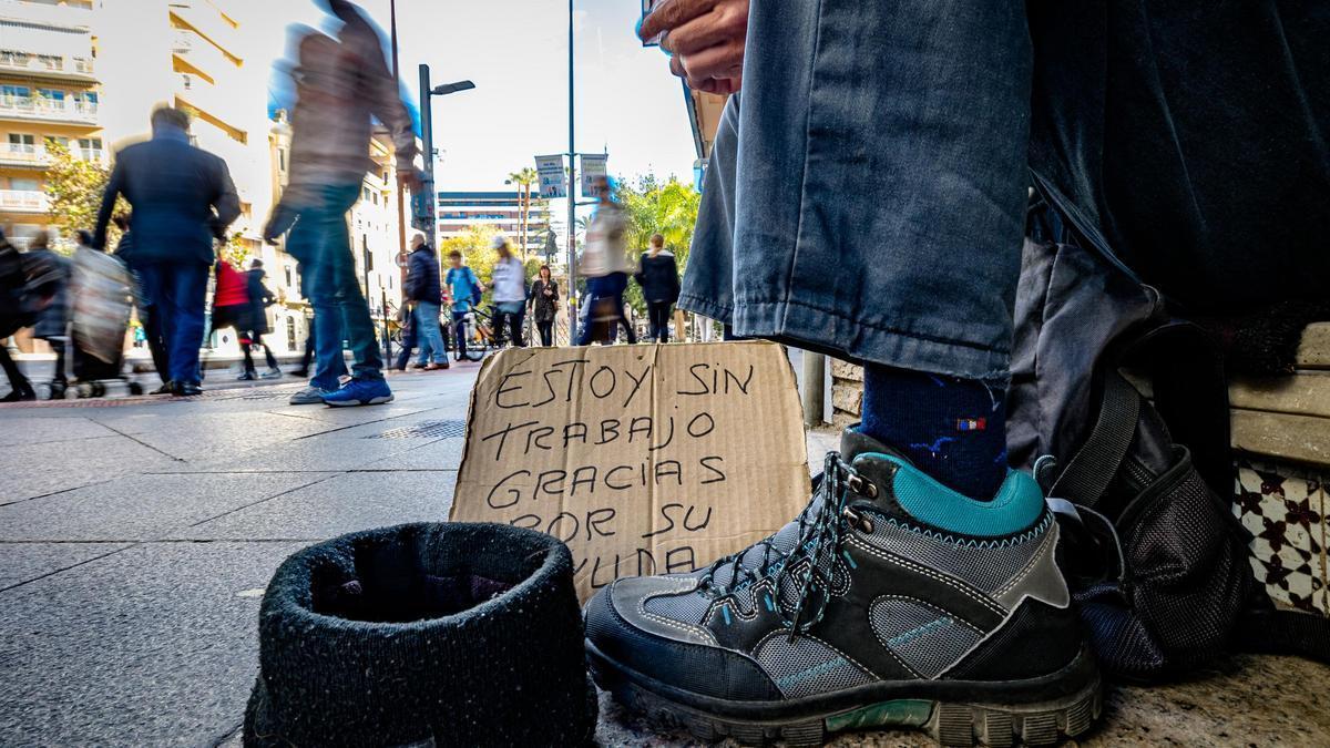 Una persona pide limosna en la calle.