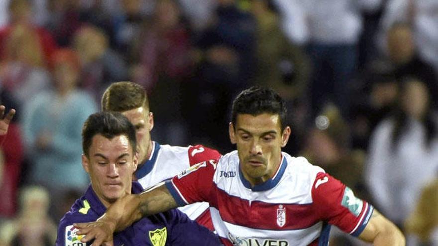 Juanpi y Ricardo Costa pelean por un balón durante el derbi entre el Granada y el Málaga de anoche.