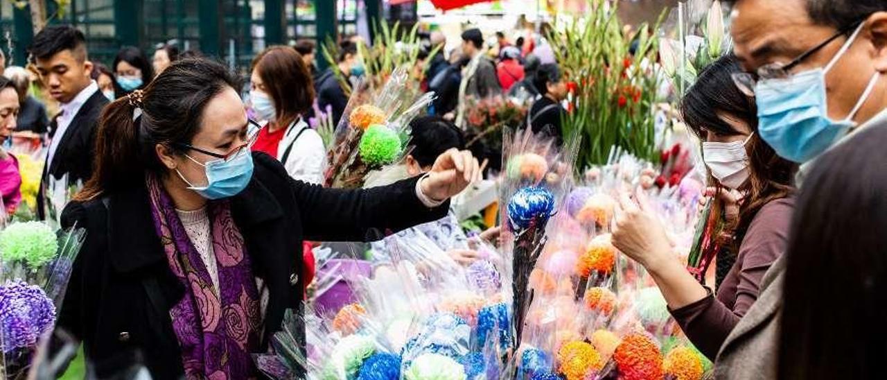 Chinos en un mercado de flores en Hong Kong, ayer, con mascarilla.