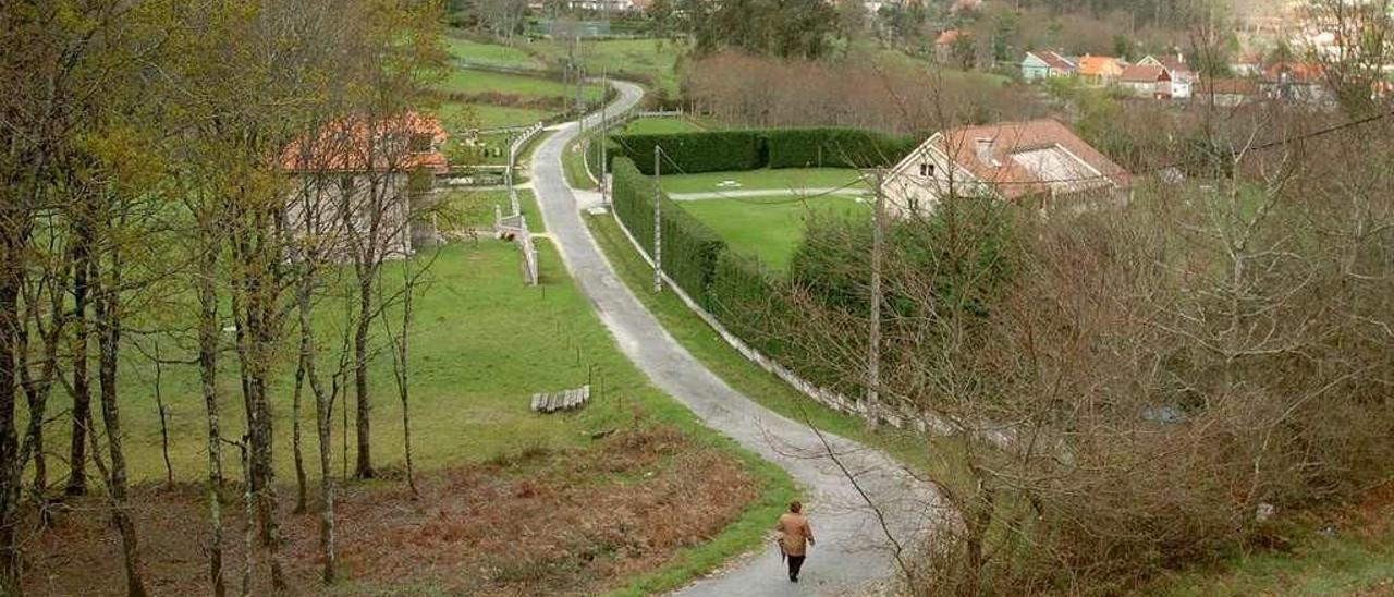 Una vecina de Ponte Caldelas camina por la zona rural próxima al casco urbano del municipio. // G. Santos