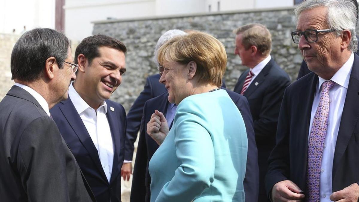 Merkel (centro), con Tsipras (izq) y Juncker (derecha), este viernes en Bratislava.