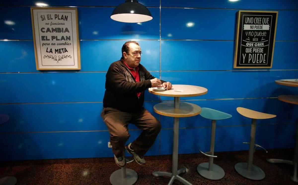 José Asensio toma un café entre dos de los nuevos carteles.