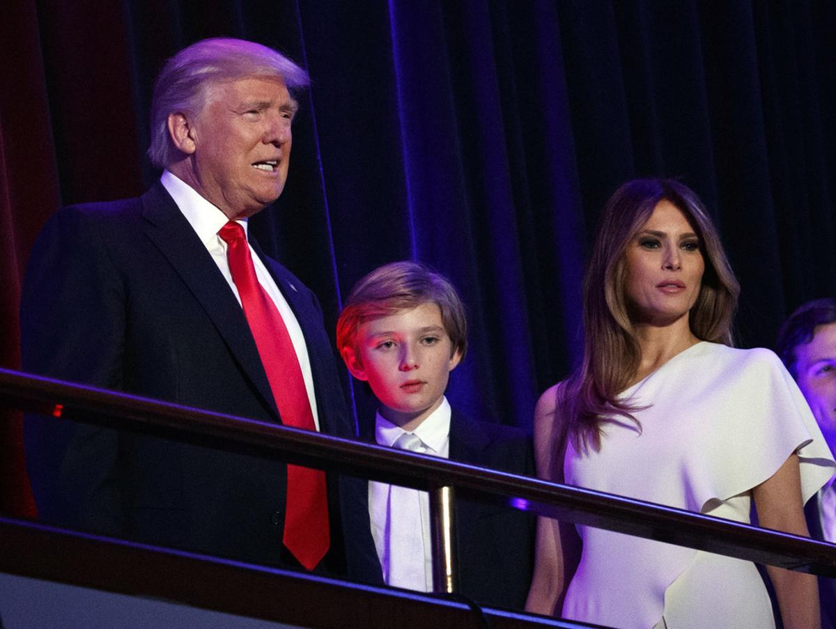 FILE - In this Nov. 9, 2016 file photo, President-elect Donald Trump, left, arrives to speak at an election night rally with his son Barron and wife Melania, in New York. Trump says he will move to the White House but his wife and young son will follow him at the end of the school year. On Sunday, Nov. 20, Trump spoke to reporters gathered at his golf club in Bedminster, N.J., during a day of private meetings with potential administration officials. (AP Photo/Evan Vucci, File)