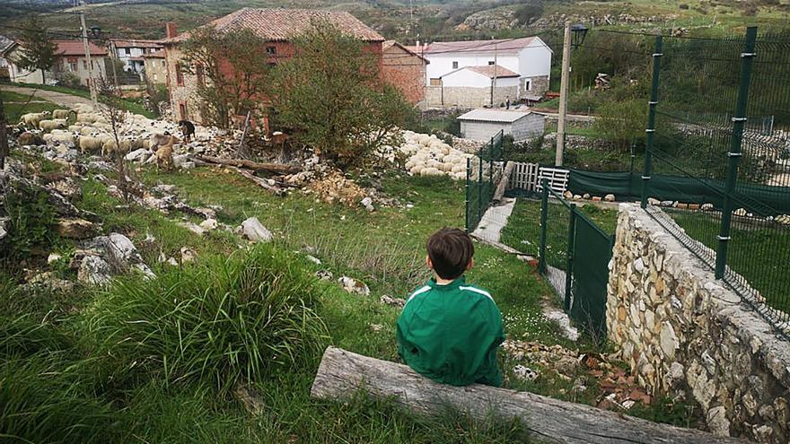 Un joven sentado a las afueras de un pueblo español.
