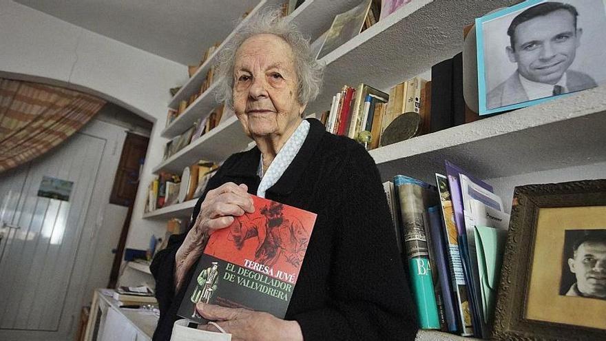 Teresa Jové, a casa seva d&#039;Esclanyà, amb un dels seus darrers llibres a les mans i unes fotos de Josep Pallach a les lleixes.