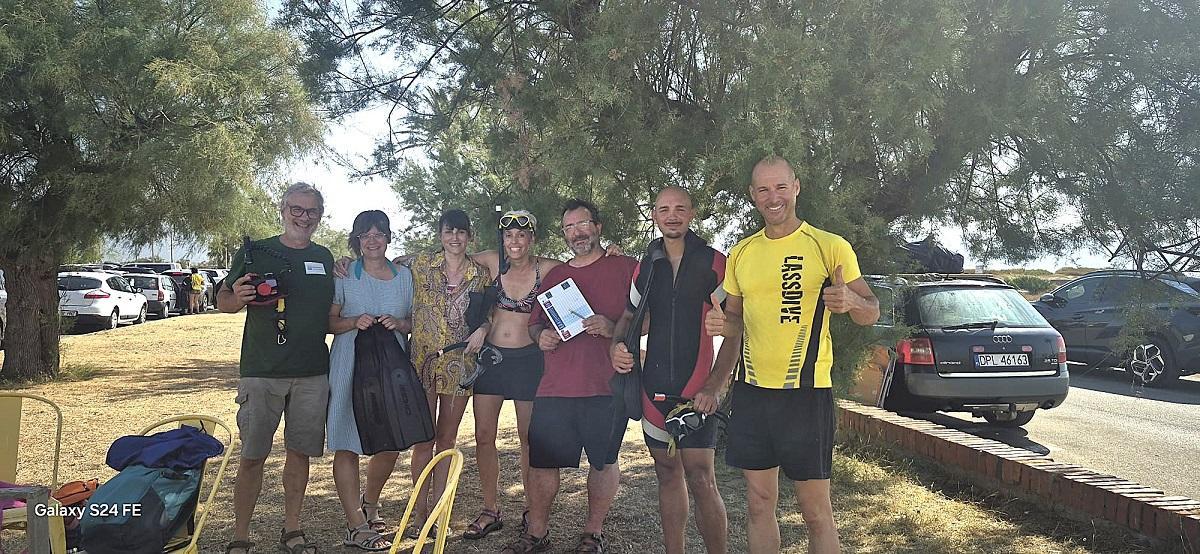 Coordinadors i participants en una fotio de grup a l'aparcament de la platja Petita