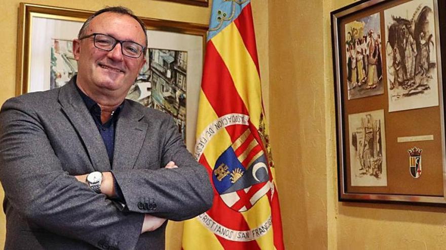 Luis Manchón en su nuevo despacho junto a la bandera de la asociación de los Moros y Cristianos.