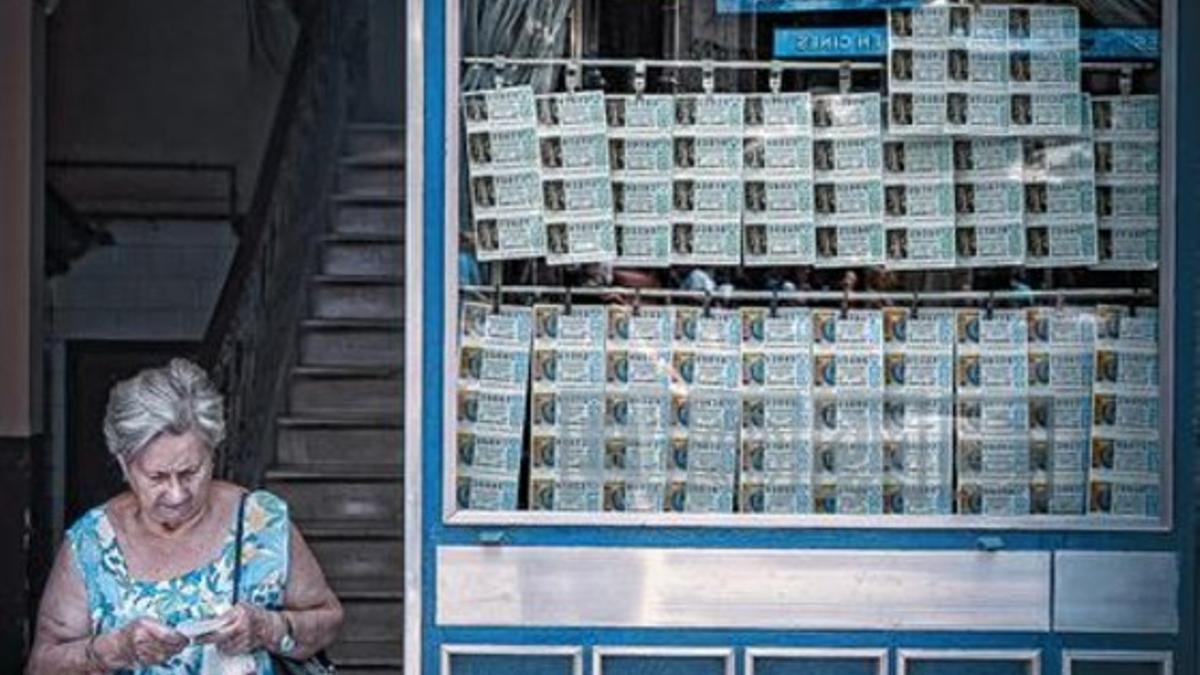 Una mujer sale, ayer, de una administración de lotería en las Rambles de Barcelona.