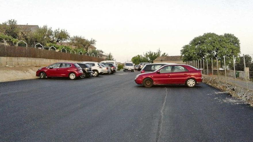 Una furgoneta accede al aparcamiento donde ya han estacionado varios vehículos.