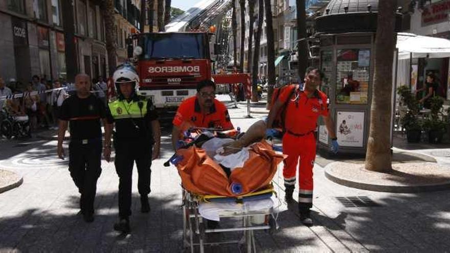 Sanitarios y agentes auxilian a un obrero herido en la Puerta del Mar en junio de 2006.