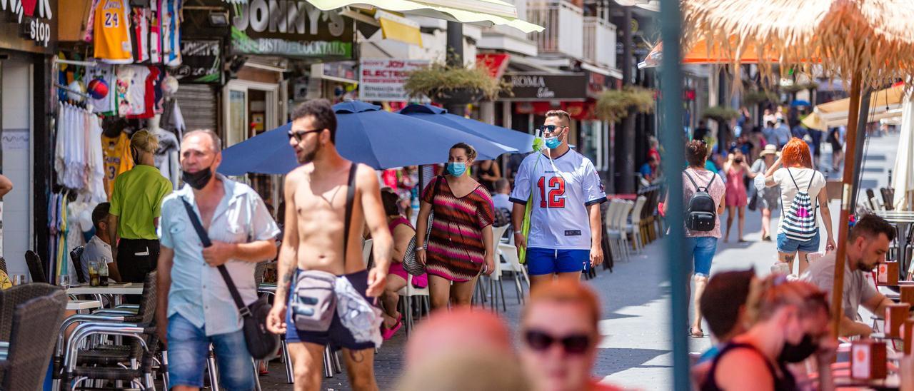 Viandantes y clientes de terrazas en el centro de Benidorm este verano.