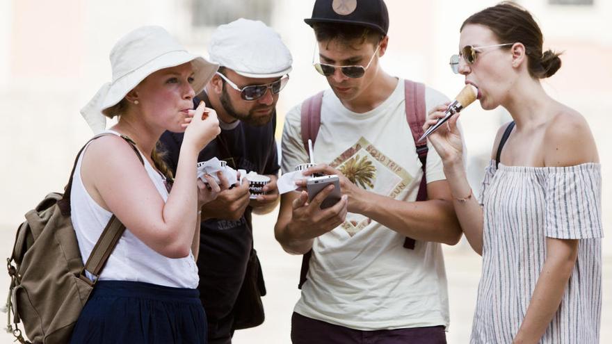 Turistas refrescándose con helados en el centro de València.