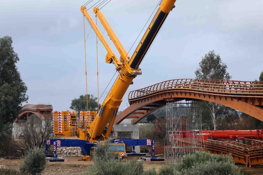 La instalación del último tramo del puente de madera sobre el río Guadalhorce ha comenzado este martes.