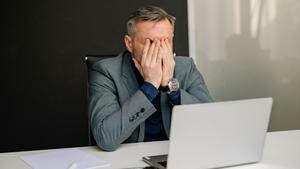 Un hombre estresado en su puesto de trabajo.