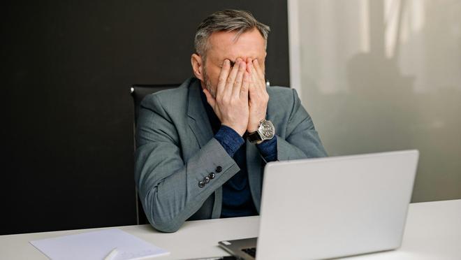 Un hombre estresado en su puesto de trabajo.