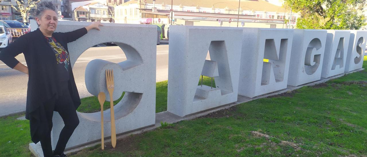 Ana PIntos, de Casa Simón, ante el nombre gigante de Cangas frente al puerto.