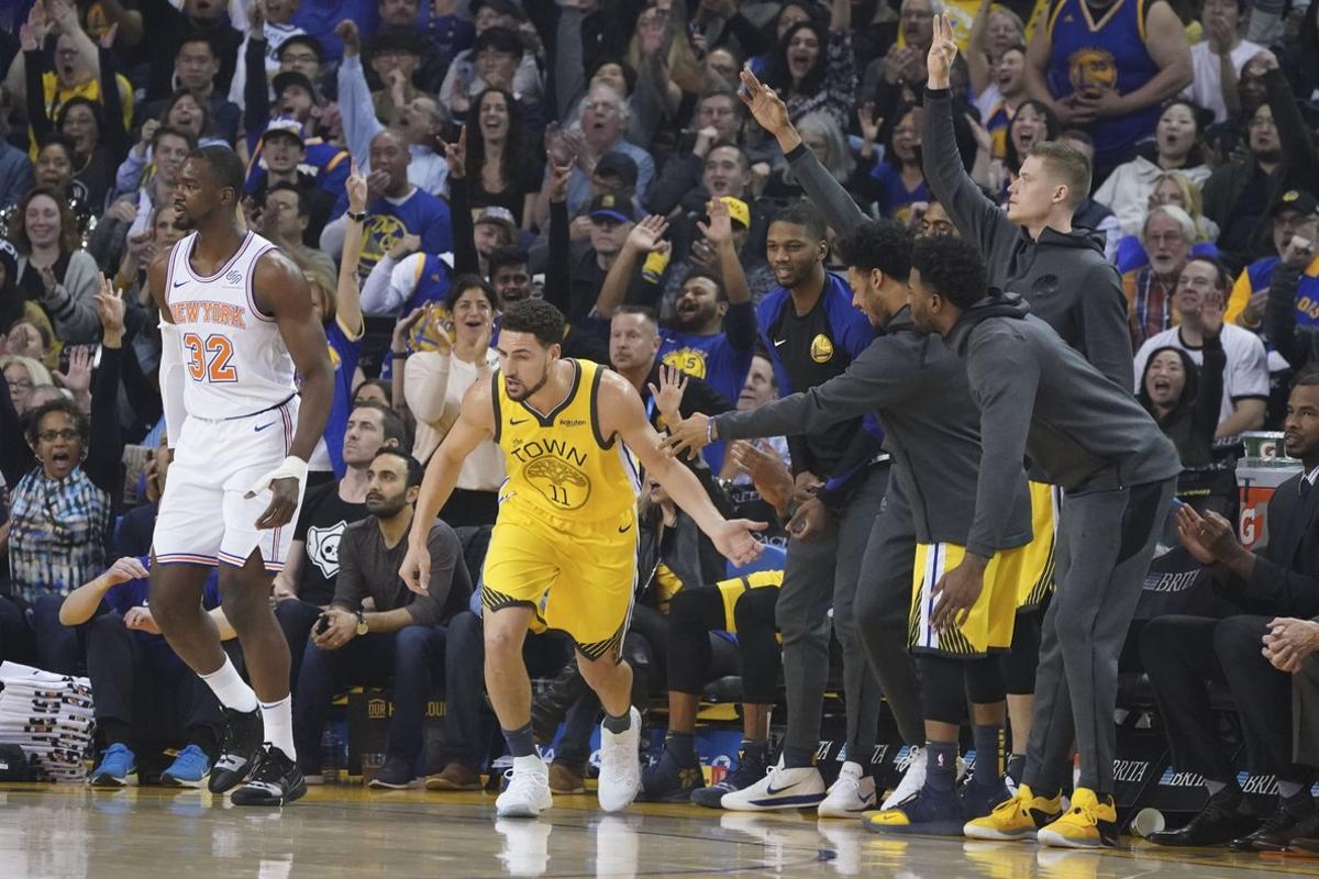 January 8, 2019; Oakland, CA, USA; Golden State Warriors guard Klay Thompson (11) is congratulated for scoring a three-point basket against New York Knicks forward Noah Vonleh (32) during the first quarter at Oracle Arena. Mandatory Credit: Kyle Terada-USA TODAY Sports