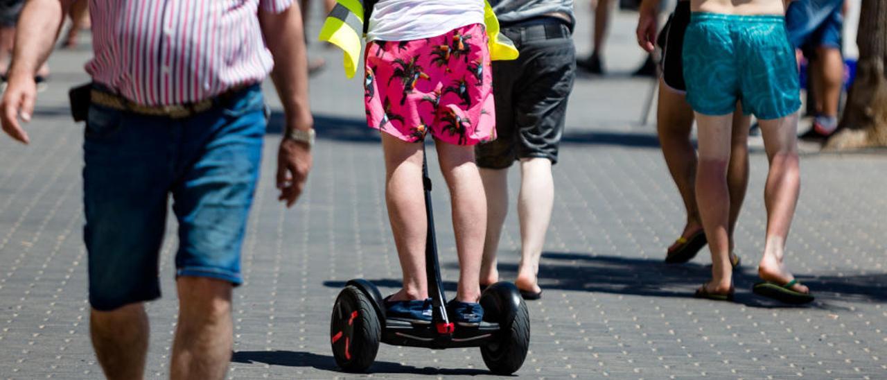 Un turista circula en un «segway» por la primera línea de la playa de Benidorm.