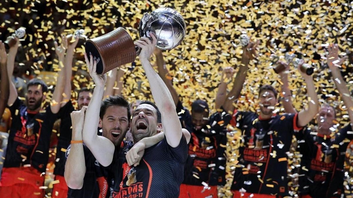 Rafa Martínez y Van Rossom alzan el trofeo ante el resto de jugadores del Valencia Basket.