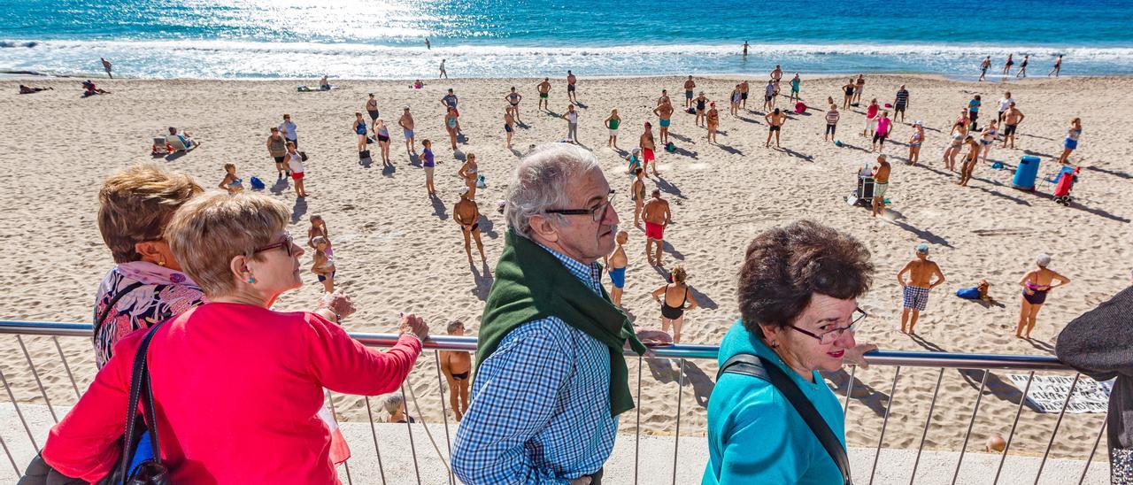 Turistas del Imserso paseando por la playa de Levante de Benidorm en el invierno de 2019