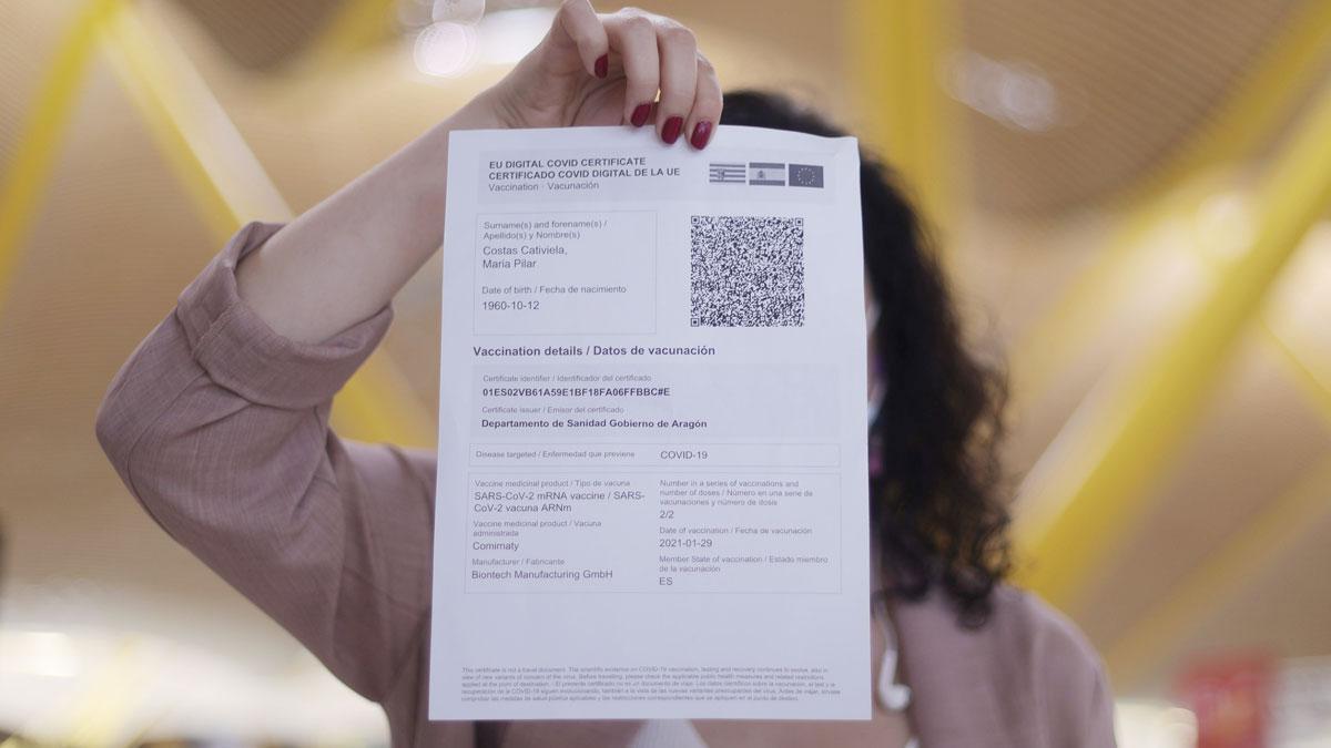 Una mujer muestra su certificado covid