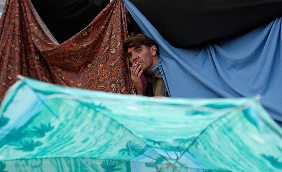 Una persona fuma un cigarret en l’acampada organitzada a Praça do Rossio, a Lisboa, en suport a les protestes espanyoles iniciades per Democràcia Real Ja.