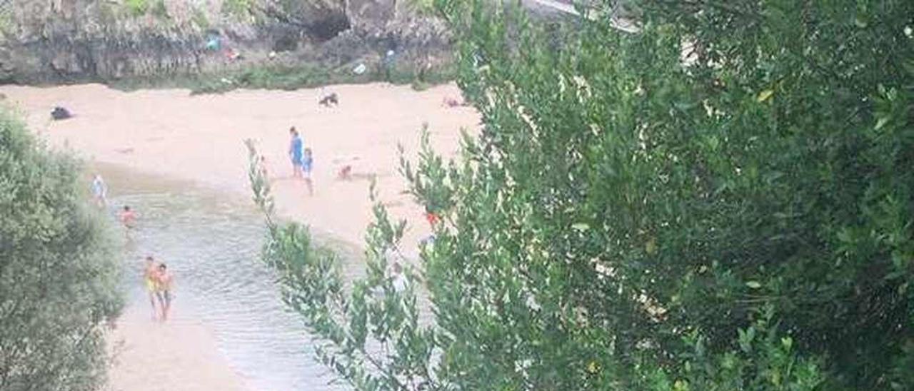 Bañistas, este verano, bajando a la playa de Guadamía.