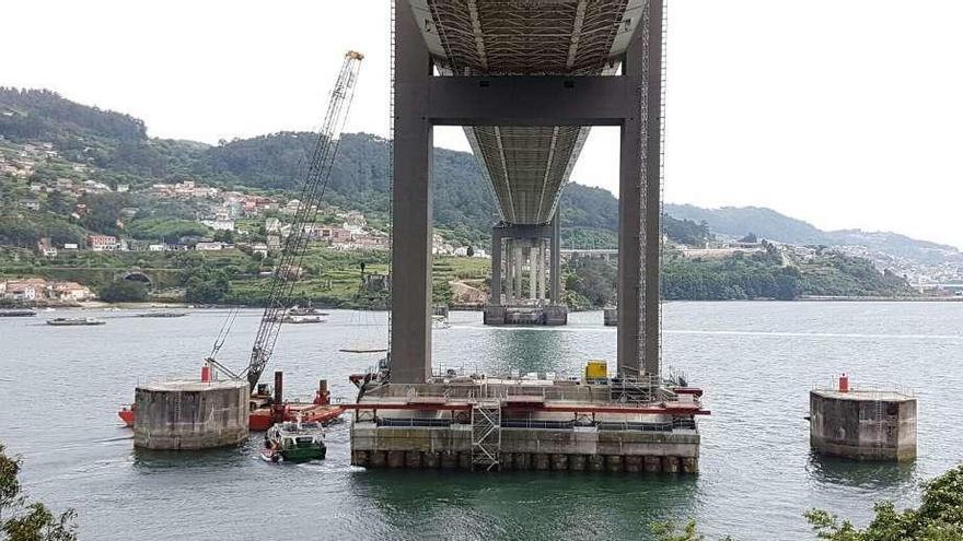 La grúa levanta desde una plataforma en el mar una de las planchas metálicas para depositarla en la pila norte, ayer en el puente de Rande. // FdV