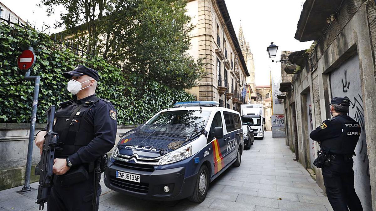 Los camiones con las obras de Plácido Arango avanzan por la calle Santa Ana de Oviedo camino del Museo de Bellas Artes, escoltados por la Policía Nacional. |