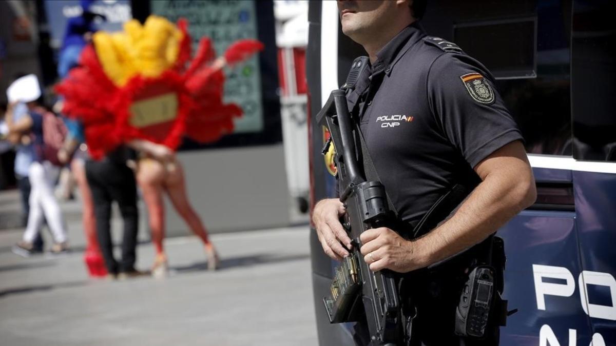 Un agente armado de la Policía Nacional vigila los alrededores de la madrileña Puerta del Sol con motivo del World Pride.